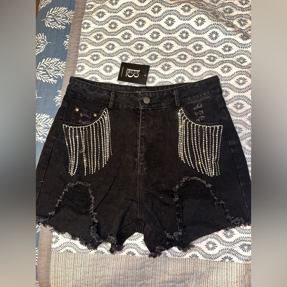 Black distressed shorts with rhinestone fringe on front pockets